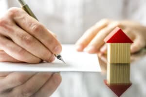 Man signing a contract when buying a new house with a septic system. Red Dirt Septic can help.