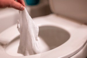 Disposable wipes being flushed down a toilet where they can cause clogging and problems with wastewater treatment. Are Flushable Wipes Safe for my septic system - Red Dirt Septic